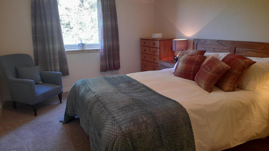 a bedroom with a bed and a chair and a window at Otters Retreat in Big Sand