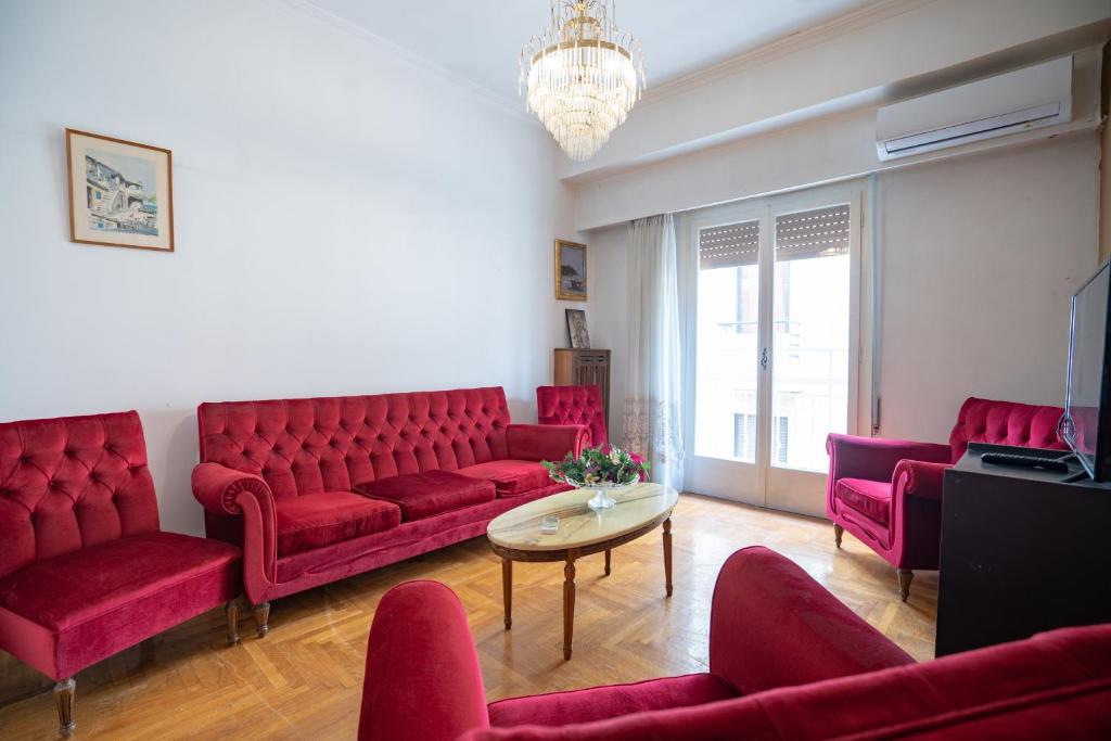 una sala de estar con sofás rojos y una mesa. en Pagrati 2 bedrooms 5 persons apartment by MPS, en Atenas