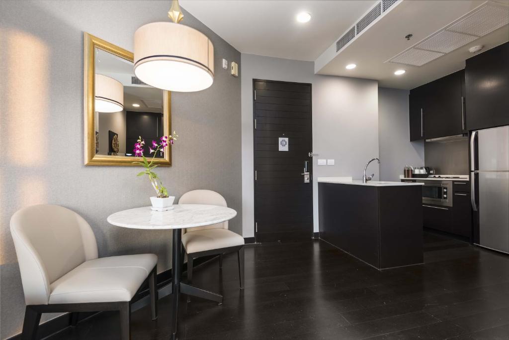 a kitchen with a table and chairs and a mirror at Chatrium Hotel Riverside Bangkok in Bangkok