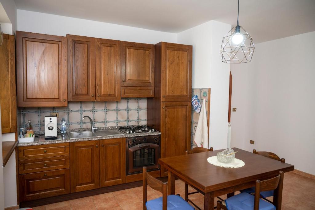 a kitchen with wooden cabinets and a wooden table with a dining room at alloggio del Viandante in Montefiascone