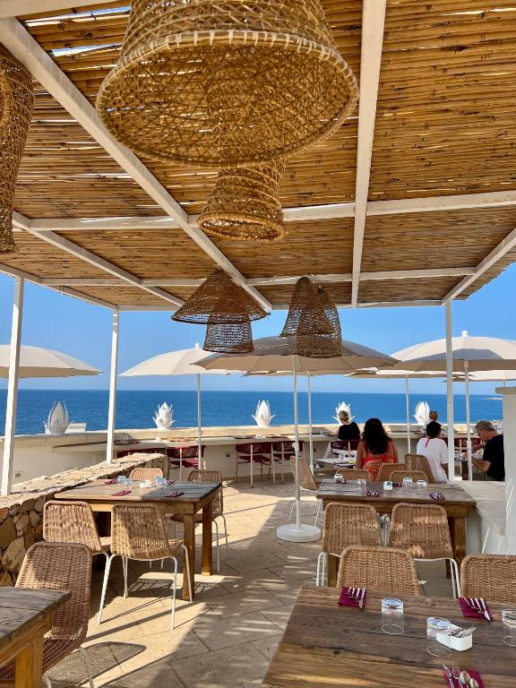 a restaurant with tables and chairs and a view of the ocean at I Bastioni San Domenico - Boutique Hotel in Gallipoli