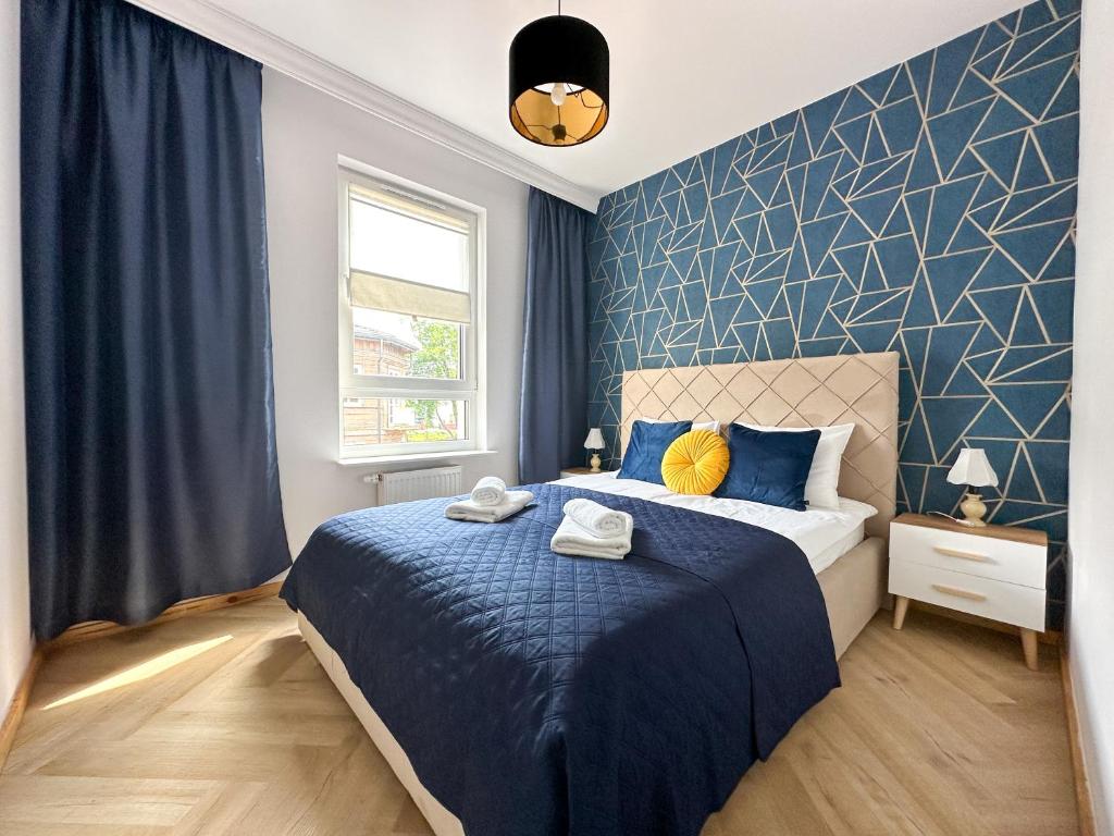 um quarto com uma cama e uma parede com um toque azul em DMK Blue Apartment near Warsaw-Modlin Airport em Nowy Dwór Mazowiecki