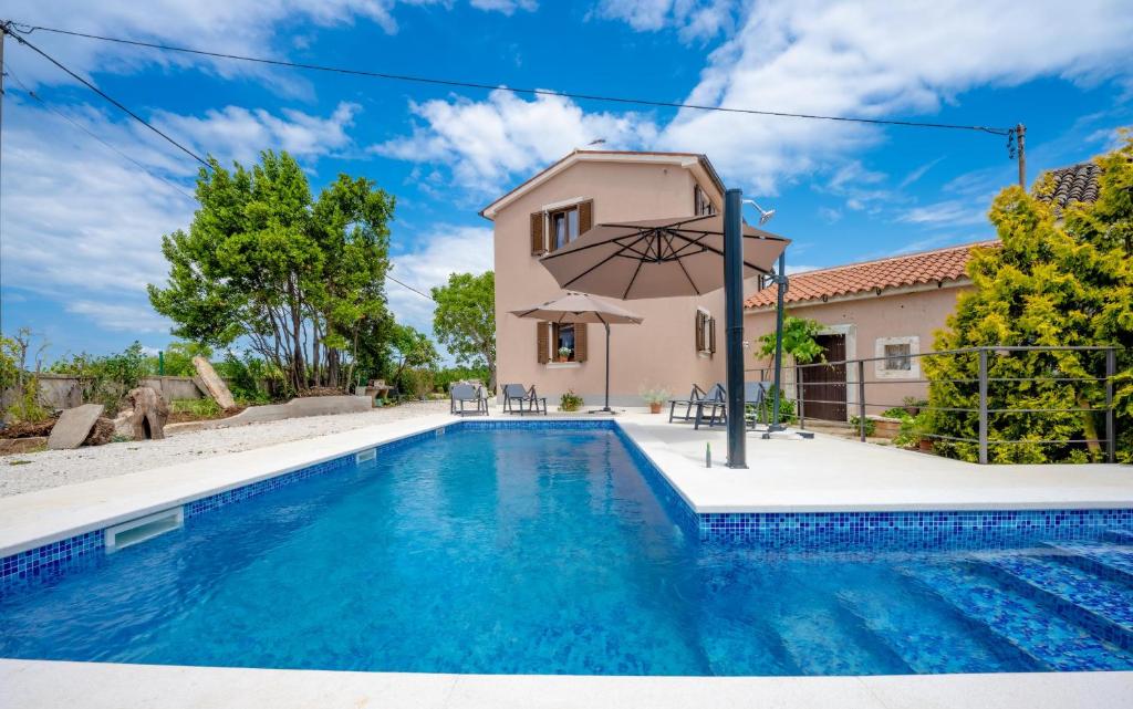 Villa con piscina frente a una casa en Holiday house Balarini en Vodnjan
