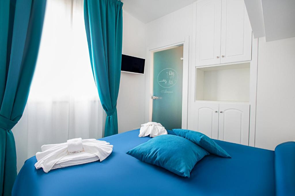 a blue bed with white towels on top of it at Hotel Villa Pandora in Maiori