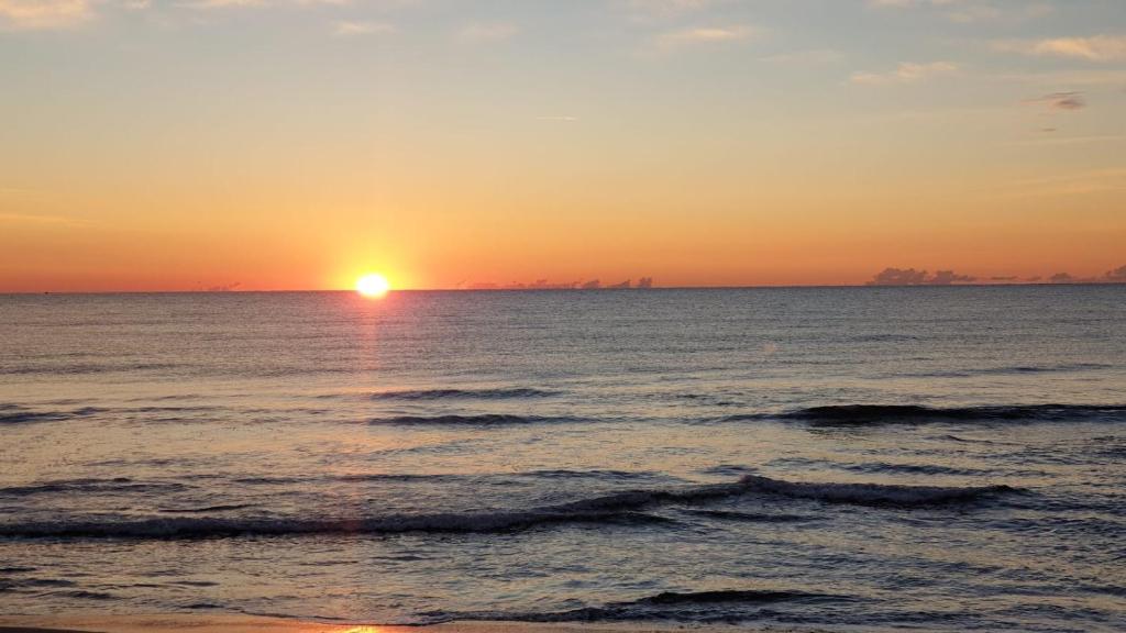 een zonsondergang op het strand met de oceaan bij Casa Gino in San Bartolomeo al Mare