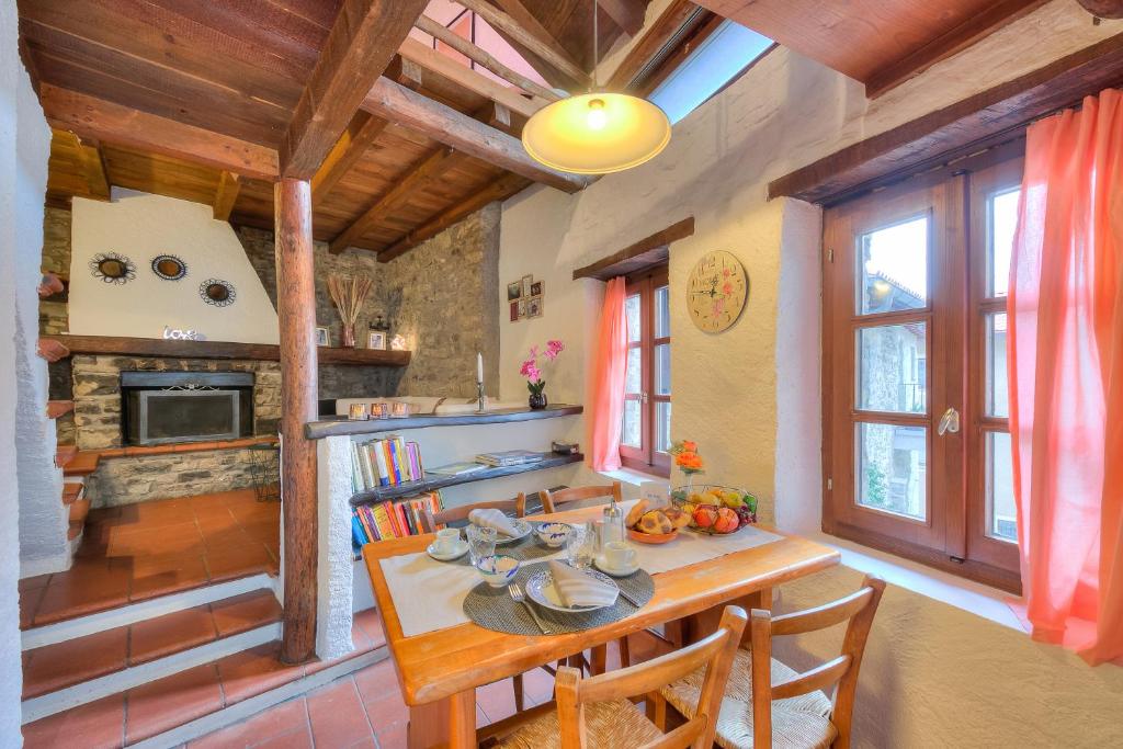 eine Küche mit einem Tisch und Stühlen sowie einem Kamin in der Unterkunft Rustico Romantico Brè - Happy Rentals in Lugano