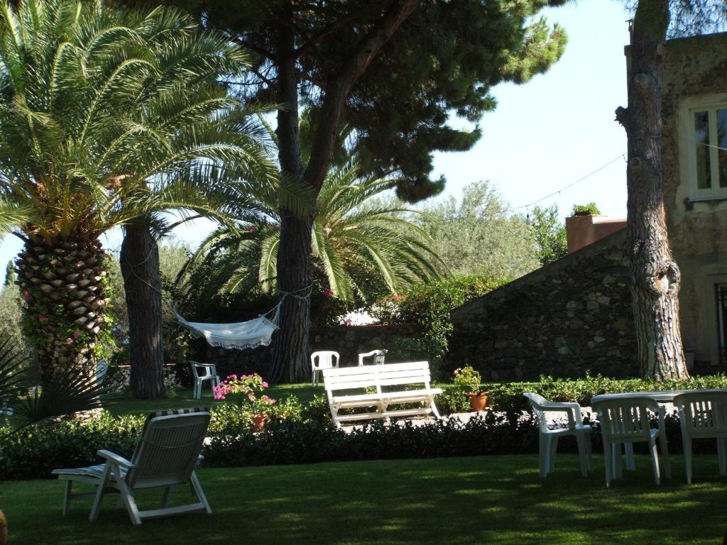 a hammock in a yard with chairs and trees at Villa Elizabeth in Milazzo