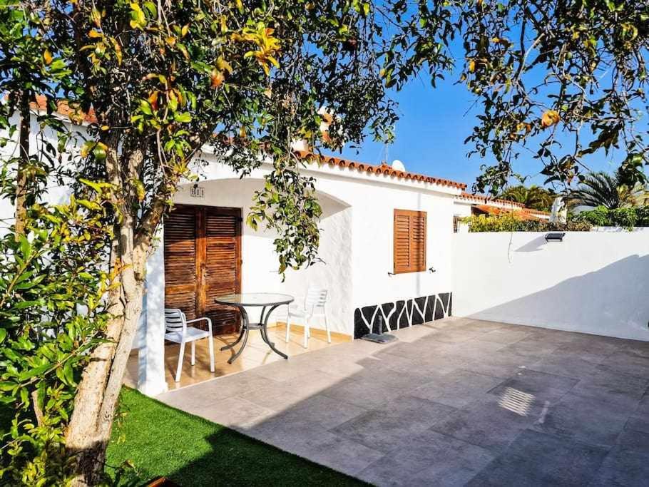 un patio con mesa y sillas frente a una casa en Acogedor Bungalow en Playa del Inglés, en Playa del Inglés