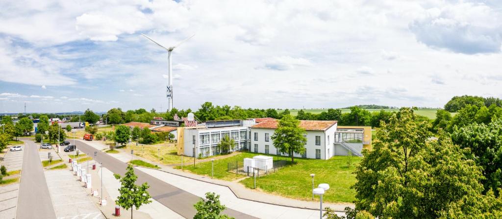 una casa con un mulino a vento in mezzo a una strada di Dresdner Tor Süd a Wilsdruff