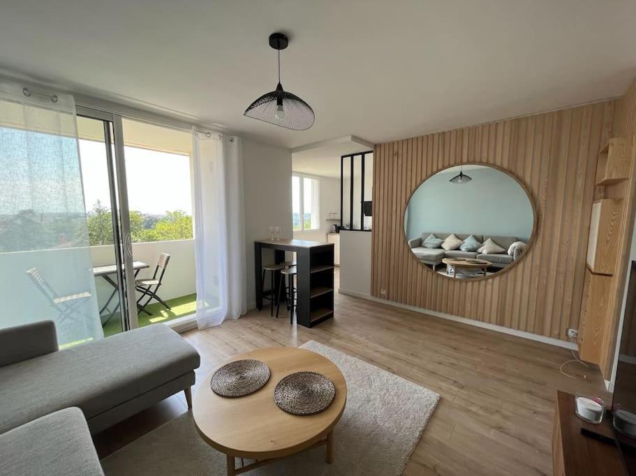 uma sala de estar com um sofá e um espelho em Le Calme - Design - Vue panoramique sur la Saône em Caluire-et-Cuire