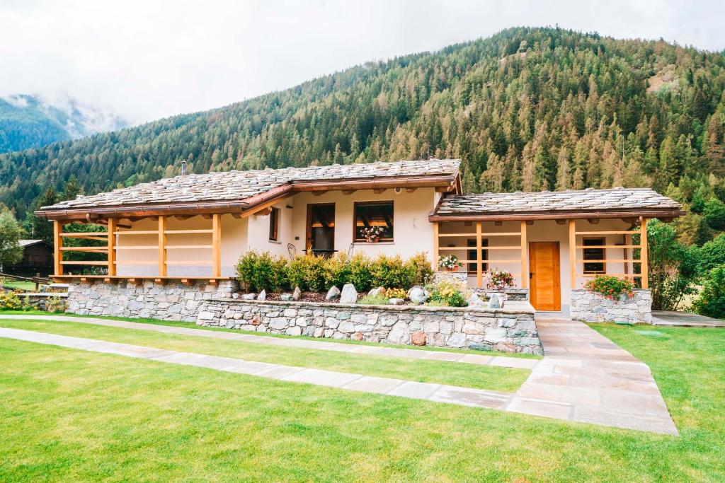 a house in the mountains with a stone wall at De Goldene Traum in Gressoney-Saint-Jean