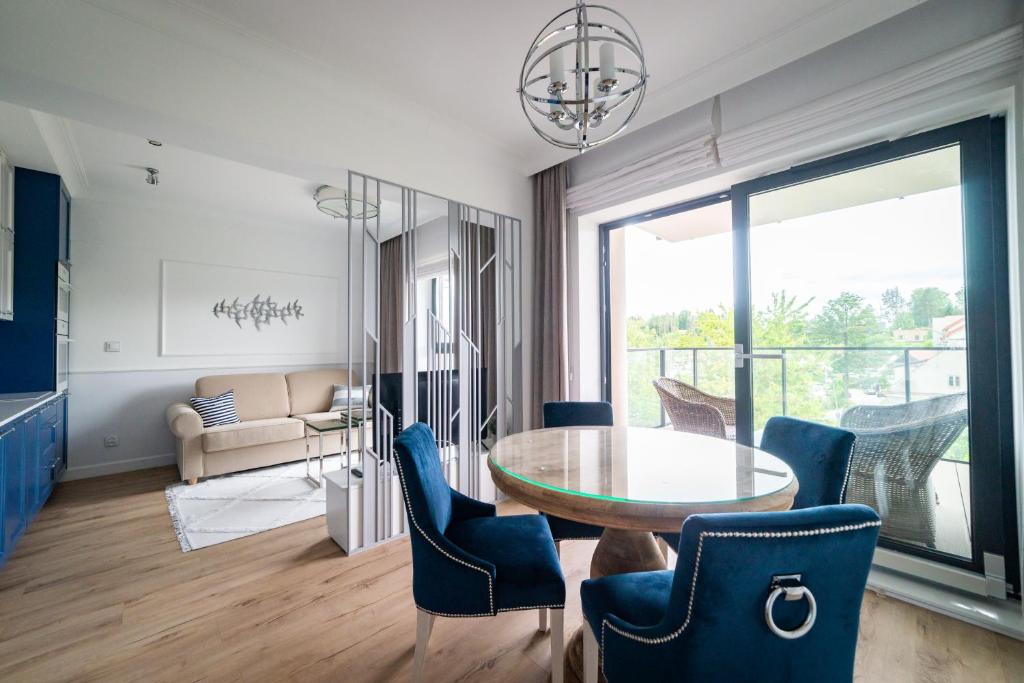 uma sala de estar com uma mesa de vidro e cadeiras em Lake Rental Spacerowa em Mikolajki