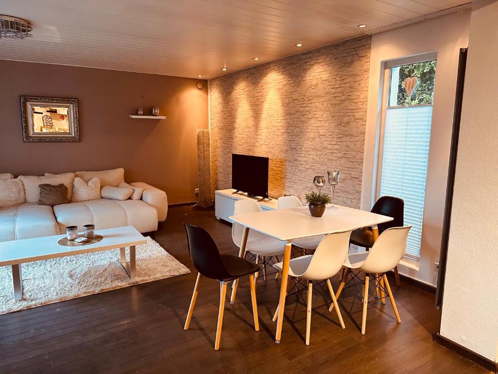 een woonkamer met een tafel en een bank bij 4 Zimmer 11 Personen Wohnung Garten Terrasse Grill 2 Badezimmer in Wuppertal