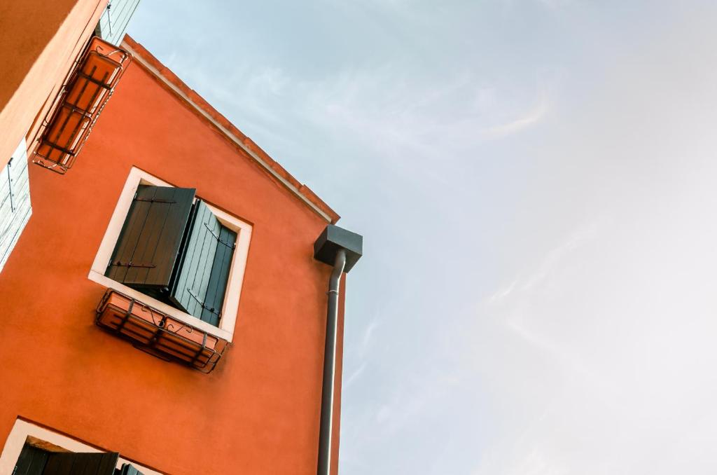 an orange building with a window and a balcony at Hotel Ariel Silva in Venice