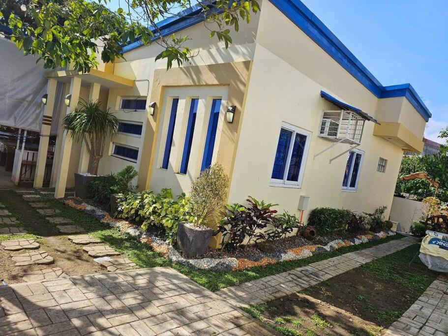 una casa con puertas azules y plantas delante de ella en D New Cabina 