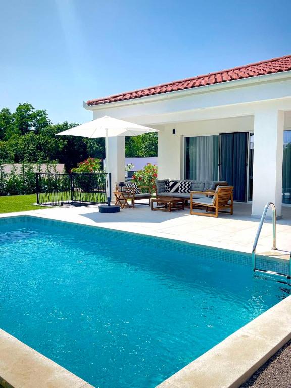a swimming pool in front of a house at Villa Destiny Nedescina, Istrien, Kroatien in Nedeščina
