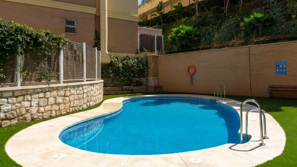 een zwembad in een tuin naast een gebouw bij Viborilla Apartment Malaga in Málaga