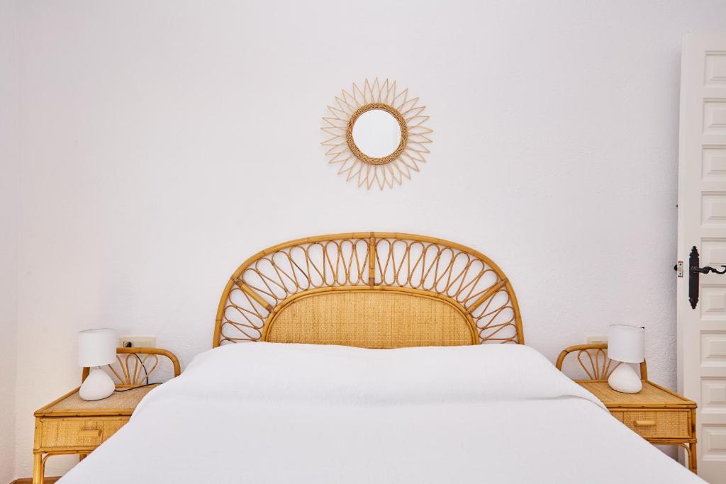 1 dormitorio con cama y espejo en la pared en Precioso aprtamento en Rocas Doradas frente al mar en L'Ametlla de Mar