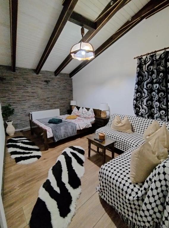 uma sala de estar com um sofá com estampa de zebra e cadeiras em Vila Maria Săsciori Sebeş em Săsciori