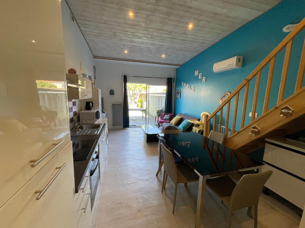 - une cuisine avec des murs bleus et un escalier dans une chambre dans l'établissement Les Mouettes, à Les Sables-dʼOlonne