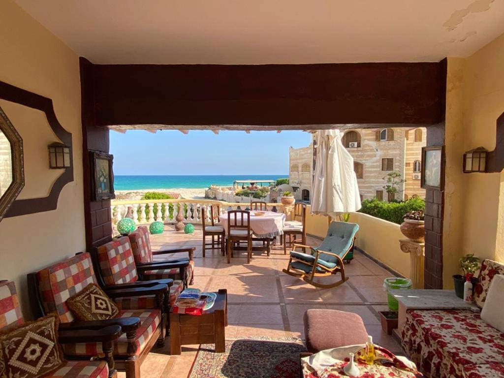 a balcony with chairs and a view of the ocean at EL Fouly Villa with beach front فيلا لمة العيله الفولي - سيدي كرير in Abû Zeira