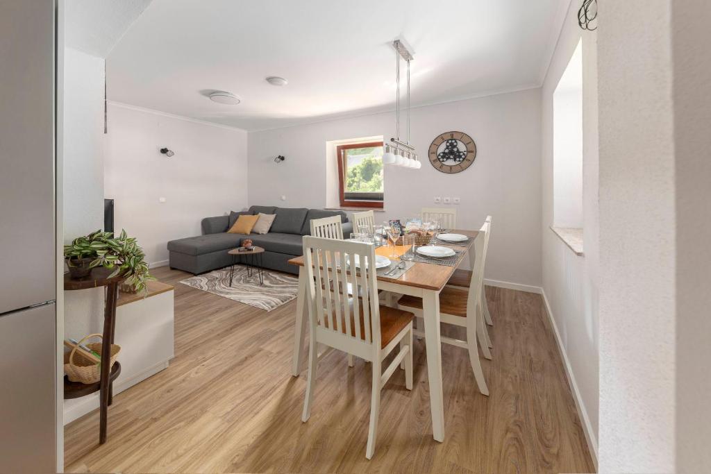 cocina y sala de estar con mesa y sillas en Apartments Ribnica, en Bohinj