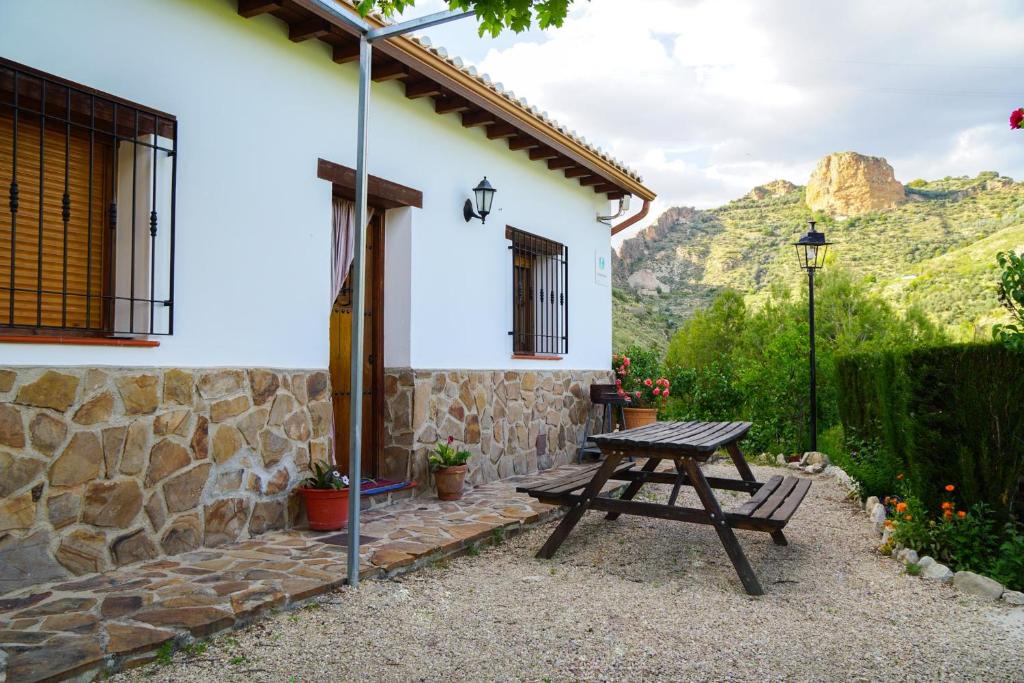 a picnic table in front of a house with mountains at Casa Rocío in Castril