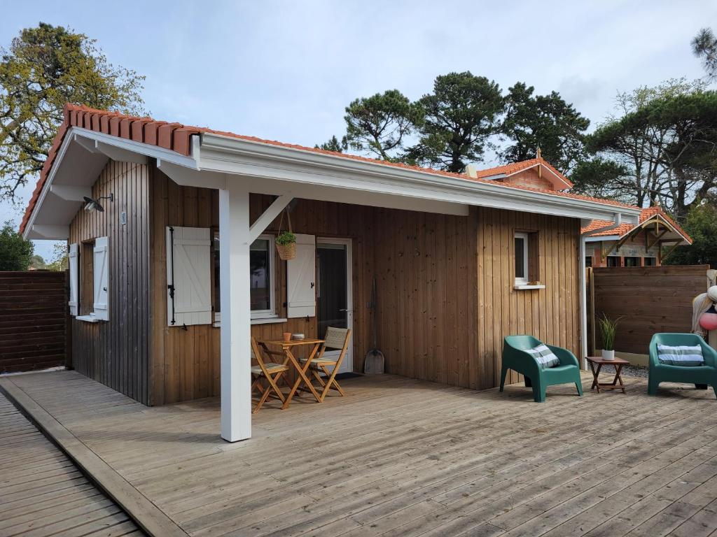 une petite maison avec une terrasse et des chaises dans l'établissement La Cabane de l'Estran au bord de mer, à Lanton