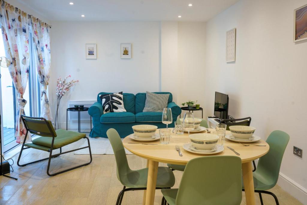 sala de estar con mesa, sillas y sofá en Gorgeous New 2 Bed Flat - 2 August House en Londres