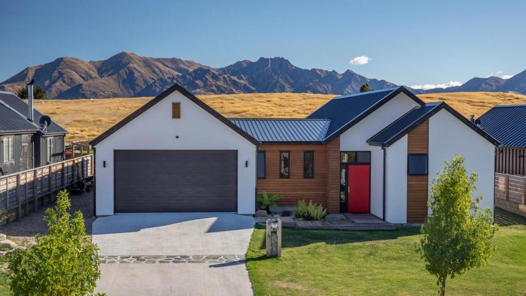a house with a garage and mountains in the background at Grandview Lodge in Wanaka
