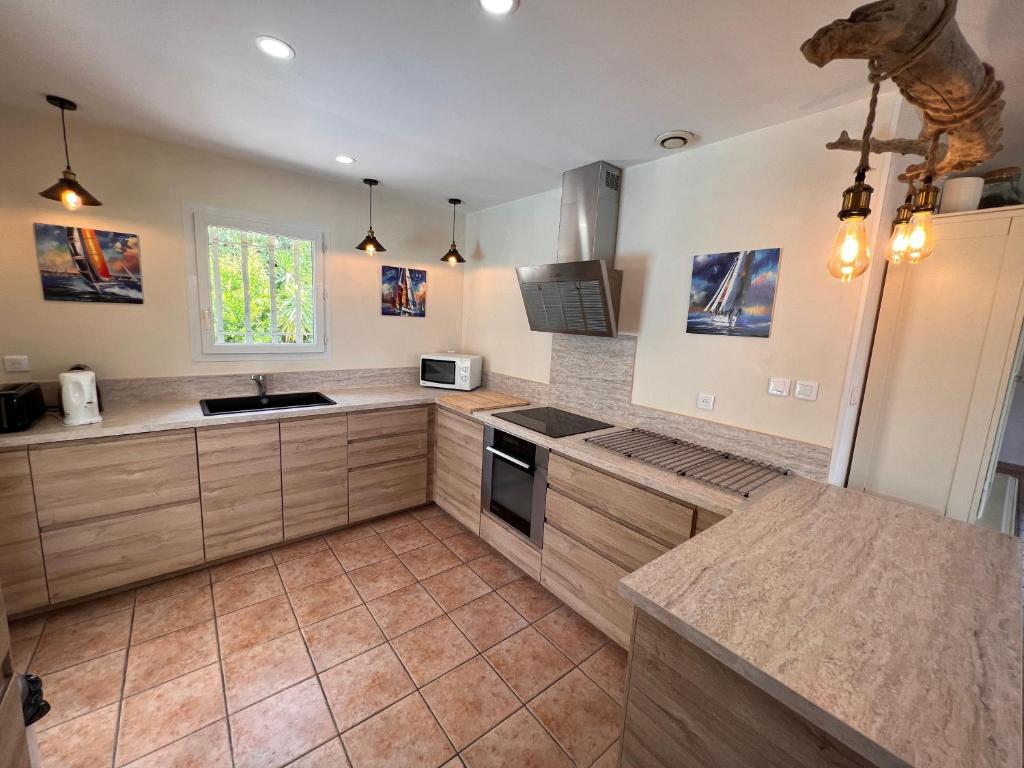 a kitchen with a sink and a stove top oven at Grande Villa à Sainte Maxime - Golfe de Saint Tropez in Sainte-Maxime