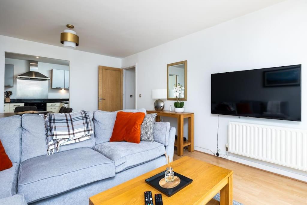 uma sala de estar com um sofá e uma televisão em Lovely 2 BR apartment with balcony em Dublin