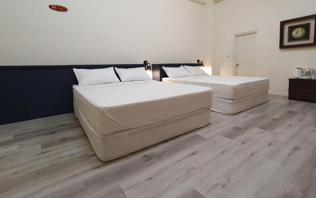 2 camas en una habitación con suelo de madera en 涵庭民宿, en Hualien City