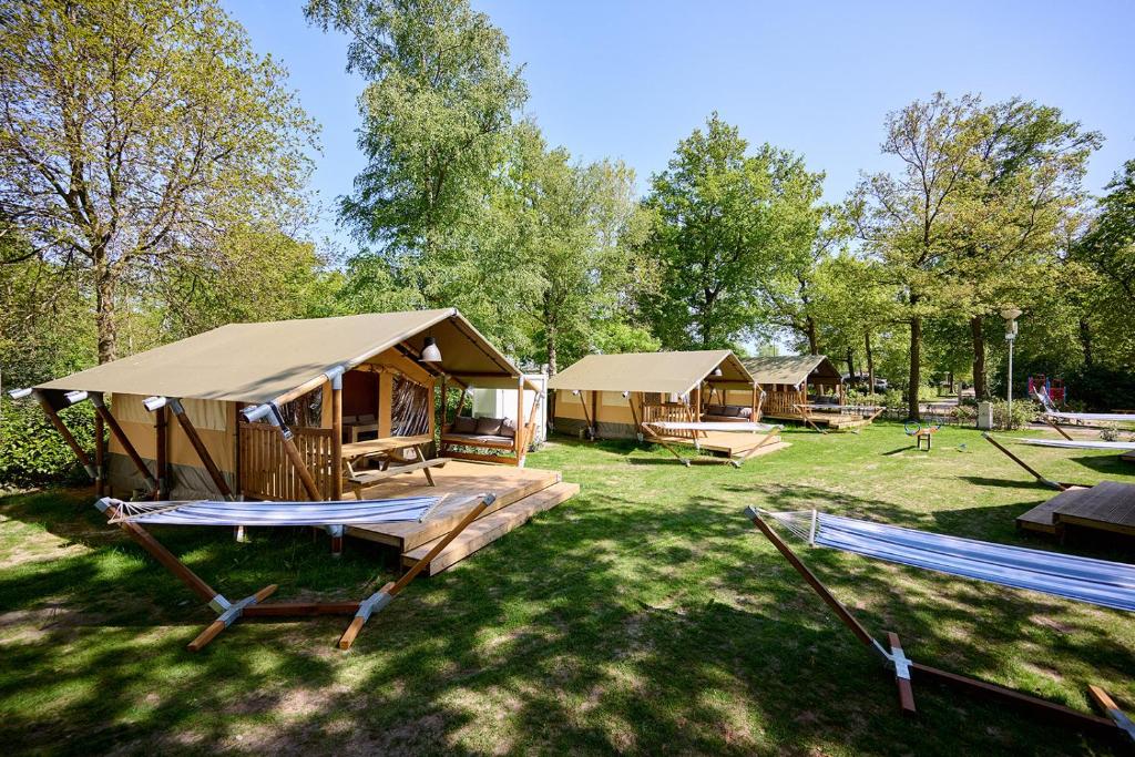 a group of lodges in a field with trees at Glamping Renswoude in Renswoude