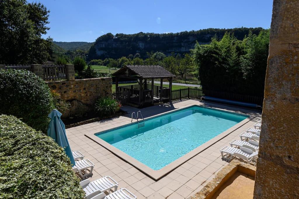 einen Pool mit Stühlen und einem Pavillon in der Unterkunft Cosy gîte with magnificent view, private terrace and shared swimming pool in Peyzac-le-Moustier