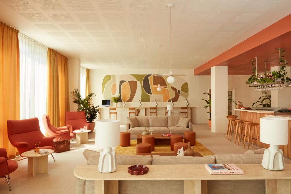 a living room with a couch and a table at OKKO Hotels Paris Rosa Parks in Paris