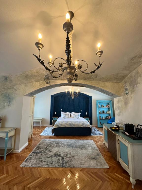 a bedroom with a large bed and a chandelier at MAGISTER seven in Sibiu