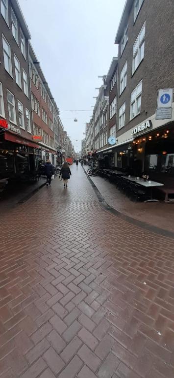 a person walking down a street with an umbrella at CHARLOTTE, not for parties, not a hotel, room with shared bathroom, no kitchen in Amsterdam