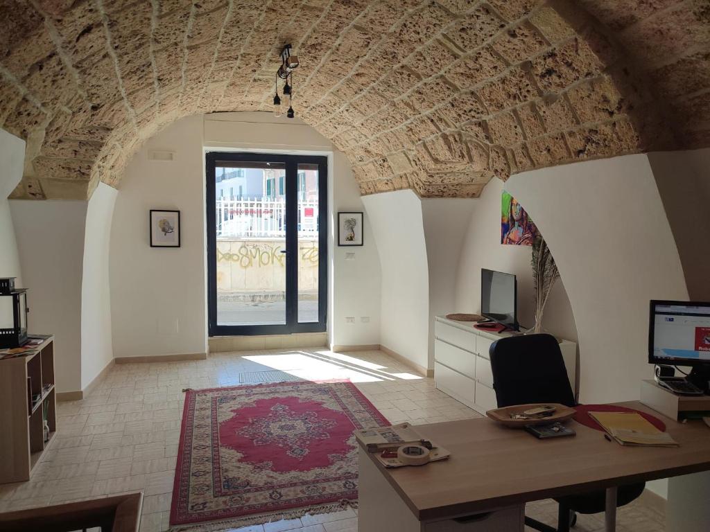 uma sala de estar com uma secretária e uma janela em Le case di Roberto em Gioia del Colle
