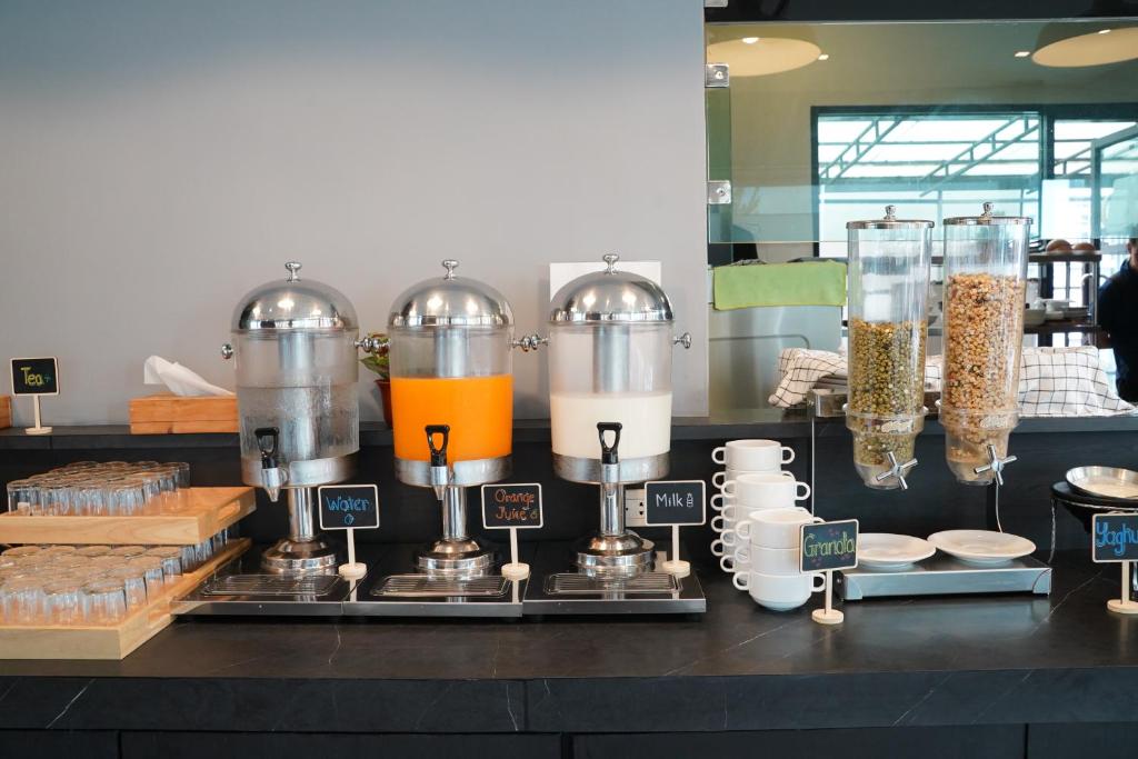 A self-service breakfast counter offers drinks, cereal, cups, and glasses.