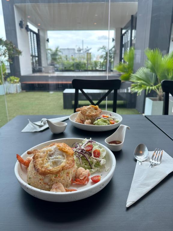 Two plated meals served at an outdoor-facing restaurant table.