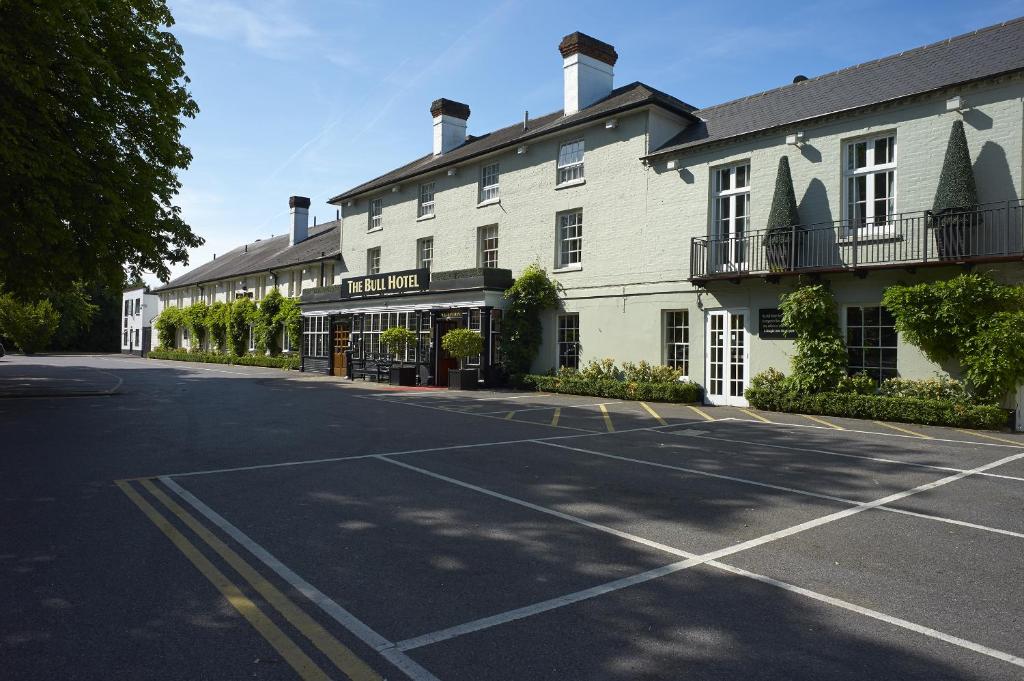 an empty street in front of a large white building at The Bull in Gerrards Cross