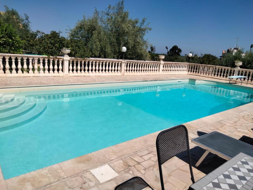 een groot zwembad met een hek eromheen bij Villa Falconara in Noto