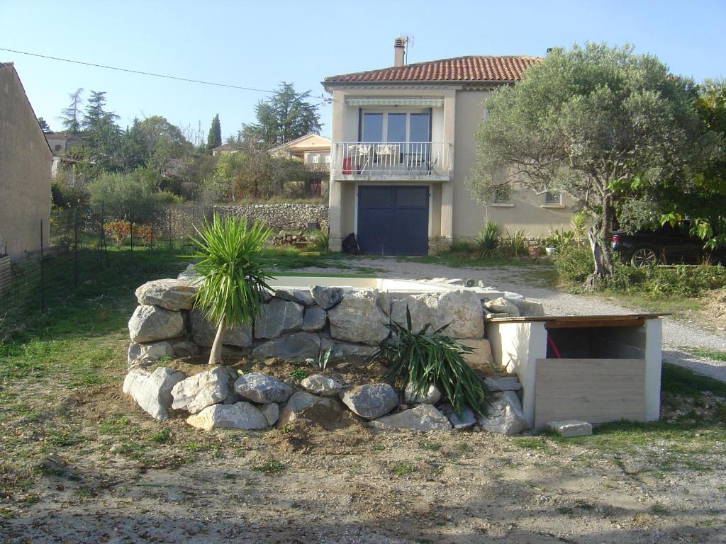a house with a stone wall in front of a yard at VILLA MI-JO in Forcalquier