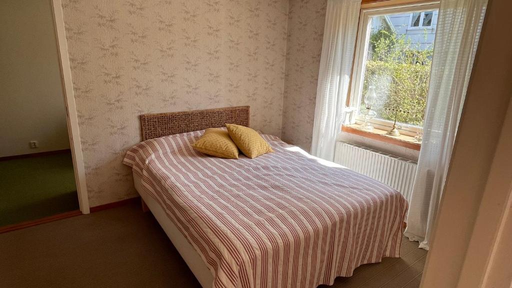 a bedroom with a bed with two pillows and a window at Ellös Holiday apartment in Ellös