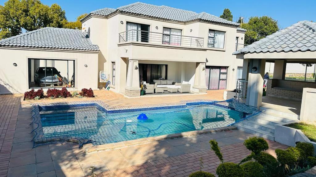 ヨハネスブルグにあるThe Hide in Sandtonの家の前にプールがある家