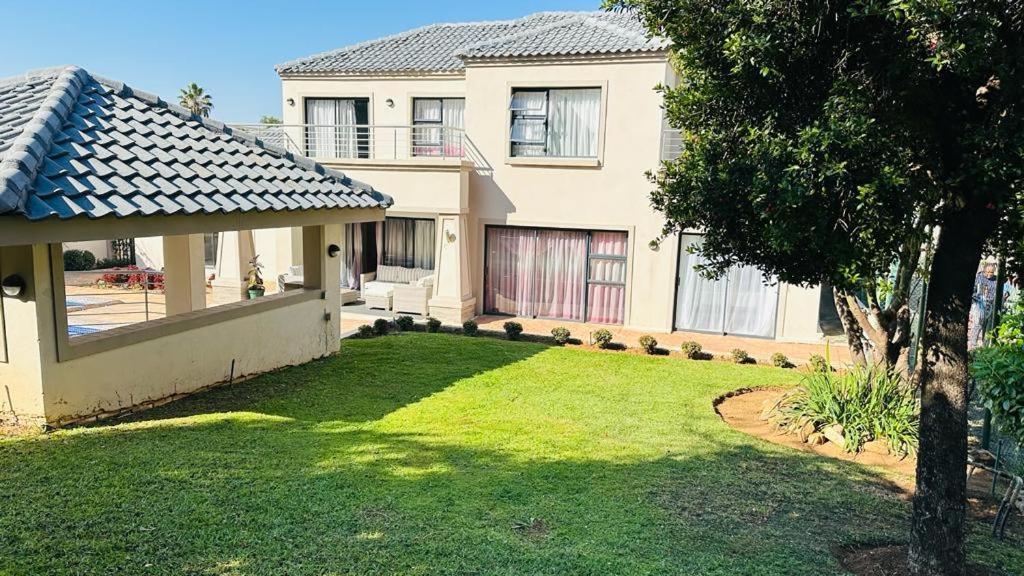 a house with a green yard in front of it at The Hide in Sandton in Johannesburg