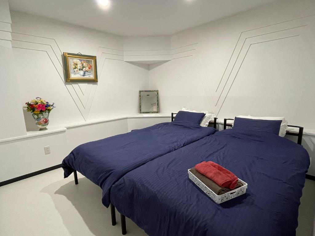 a bedroom with a bed with a blue comforter at Zenibako House 1f in Otaru