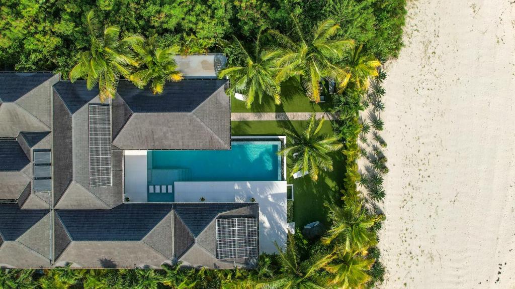 - une vue aérienne sur un complexe avec une piscine et des palmiers dans l'établissement VIP The Beach House, à Jolly Harbour
