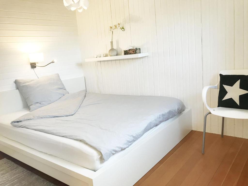 uma cama branca num quarto branco com uma mesa em Business Apartment TUSCANY mit großer Gartenterrasse em Reutlingen